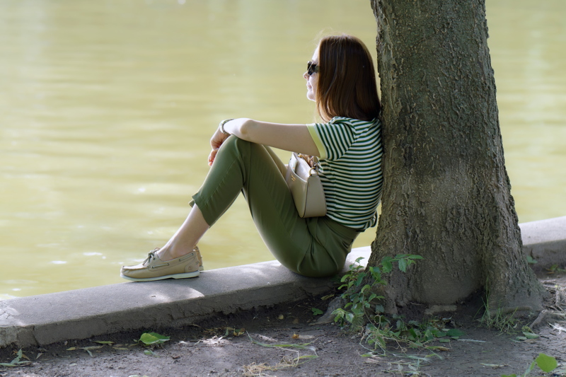 1 - A quiet moment by the water, featuring a person dressed in casual summer attire